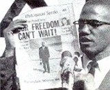 Malcolm X con una copia del "Muhammad Speaks"